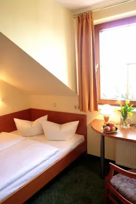 Ein Bett oder Betten in einem Zimmer der Unterkunft Landhotel Dresden