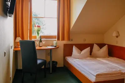 Ein Bett oder Betten in einem Zimmer der Unterkunft Landhotel Dresden