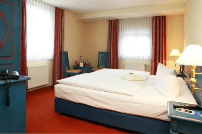 Ein Bett oder Betten in einem Zimmer der Unterkunft Hotel Erbgericht Buntes Haus